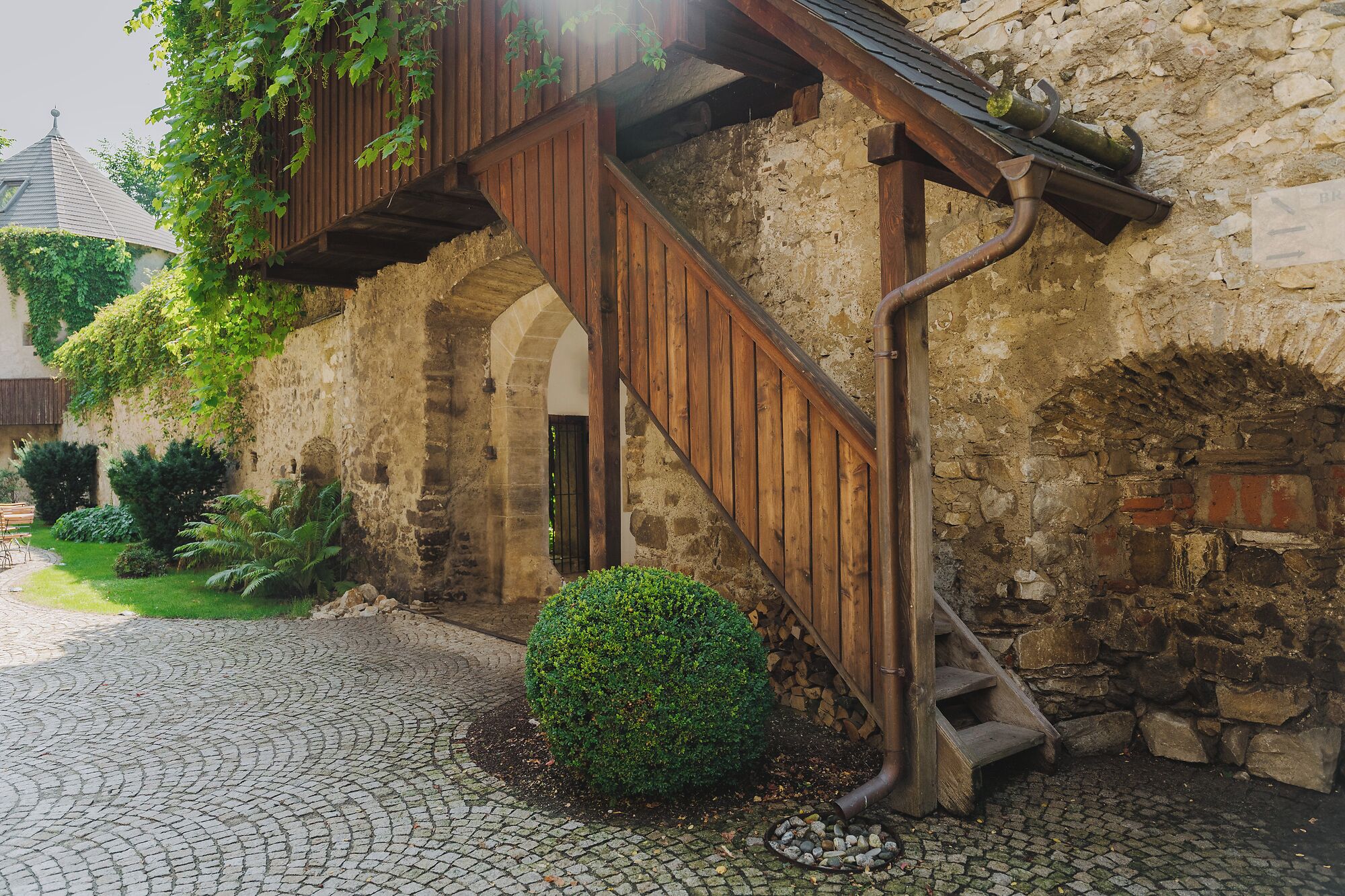 A stone building with a wooden staircase leading to an upper level.