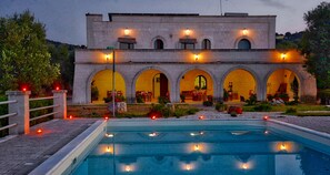 Un bâtiment doté d’une piscine, avec des portes en arc de cercle et des espaces de détente en plein air.