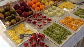 A buffet table with various fruits and snacks.