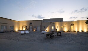Relax in the serene courtyard, surrounded by comfortable lounge chairs and a unique stone sculpture.