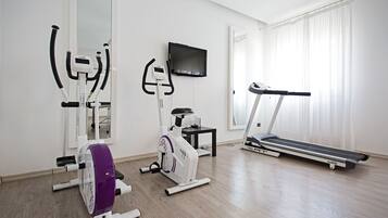 Ein Fitnessraum mit Laufband, Crosstrainer und Ergometer.