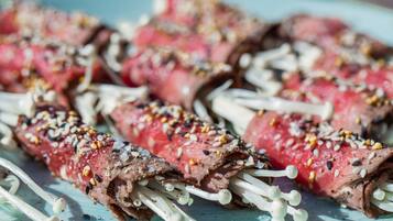 Spiesjes vlees met sesamzaadjes en champignons op een bord.