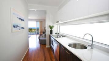 Una cocina moderna con un ventanal grande, suelo de madera y vistas al exterior.