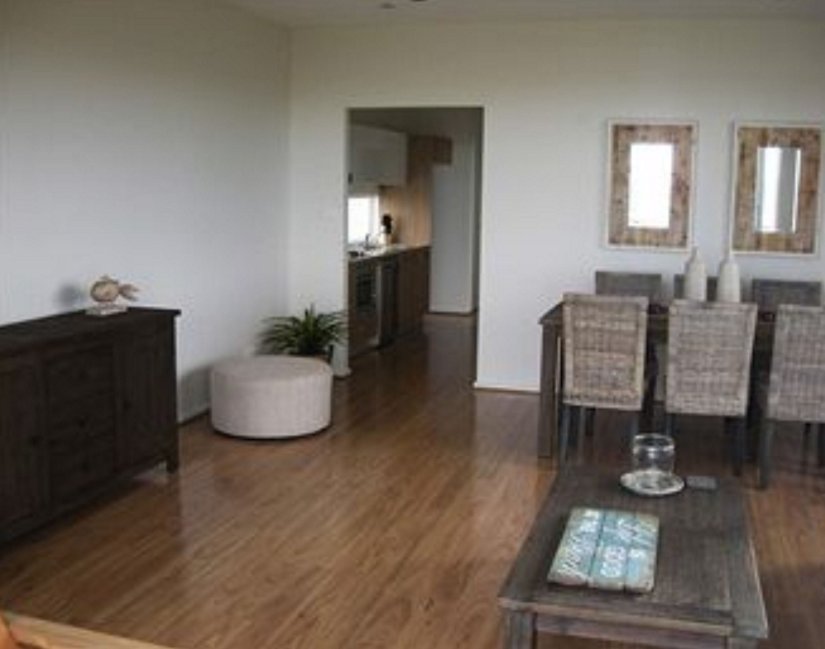 A dining area with a wooden table, chairs, and a small potted plant.