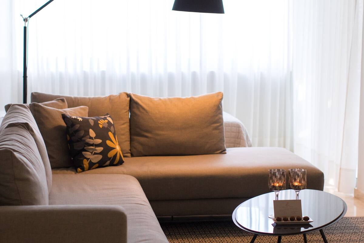 A modern living room with a sofa, a coffee table, and a floor lamp.