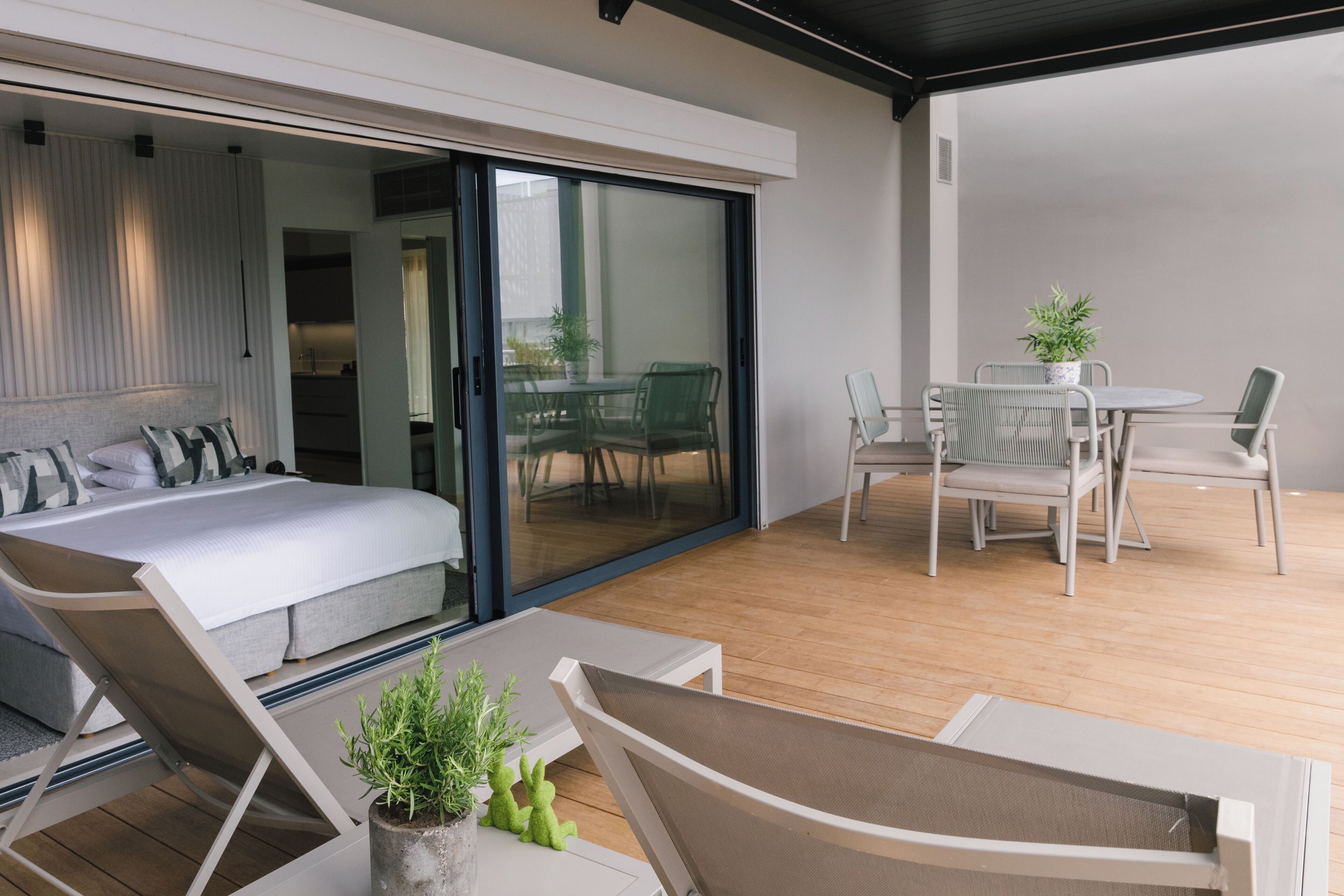 Een moderne slaapkamer met een grote schuifglazen deur naar een balkon.