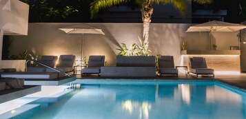 Una piscina al aire libre de temporada, sombrillas