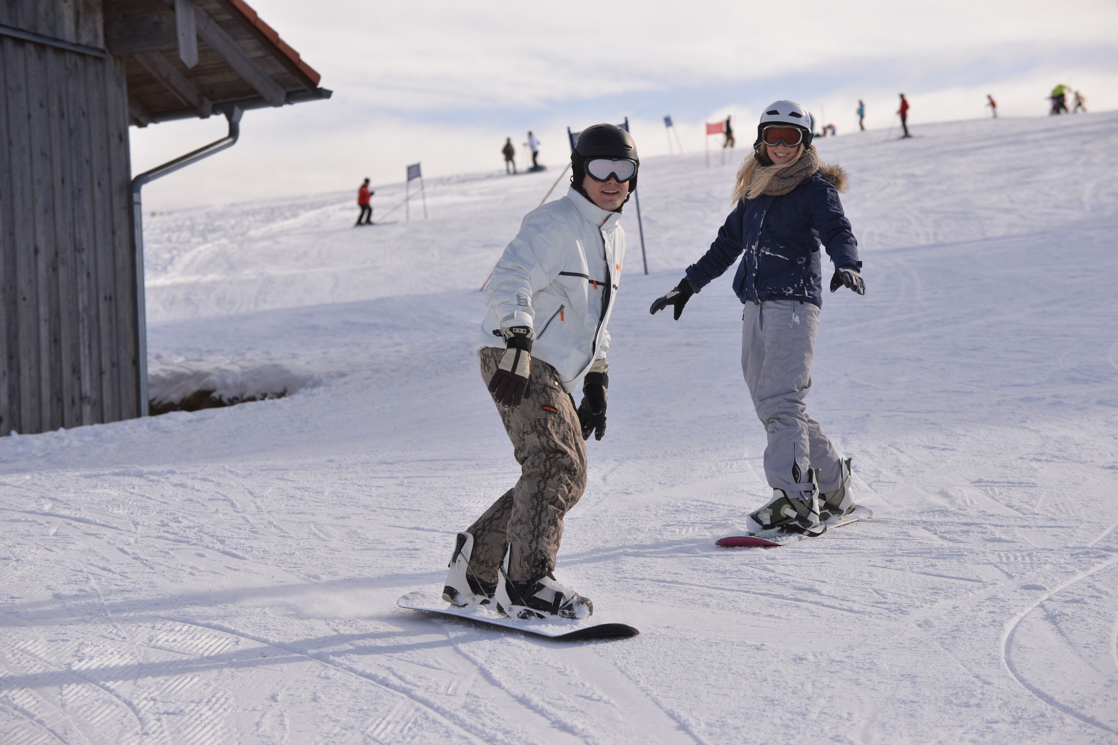 A snow-covered slope with skiers and snowboarders.