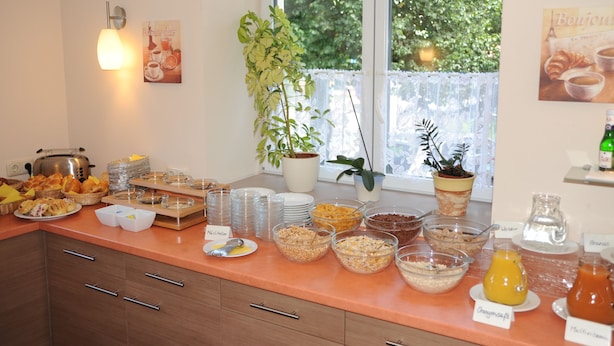 Un bufé de desayuno con diferentes alimentos y una planta en maceta.