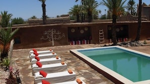A poolside area with lounge chairs and a swimming pool. - Kasbah Dar Essalam (Skoura)