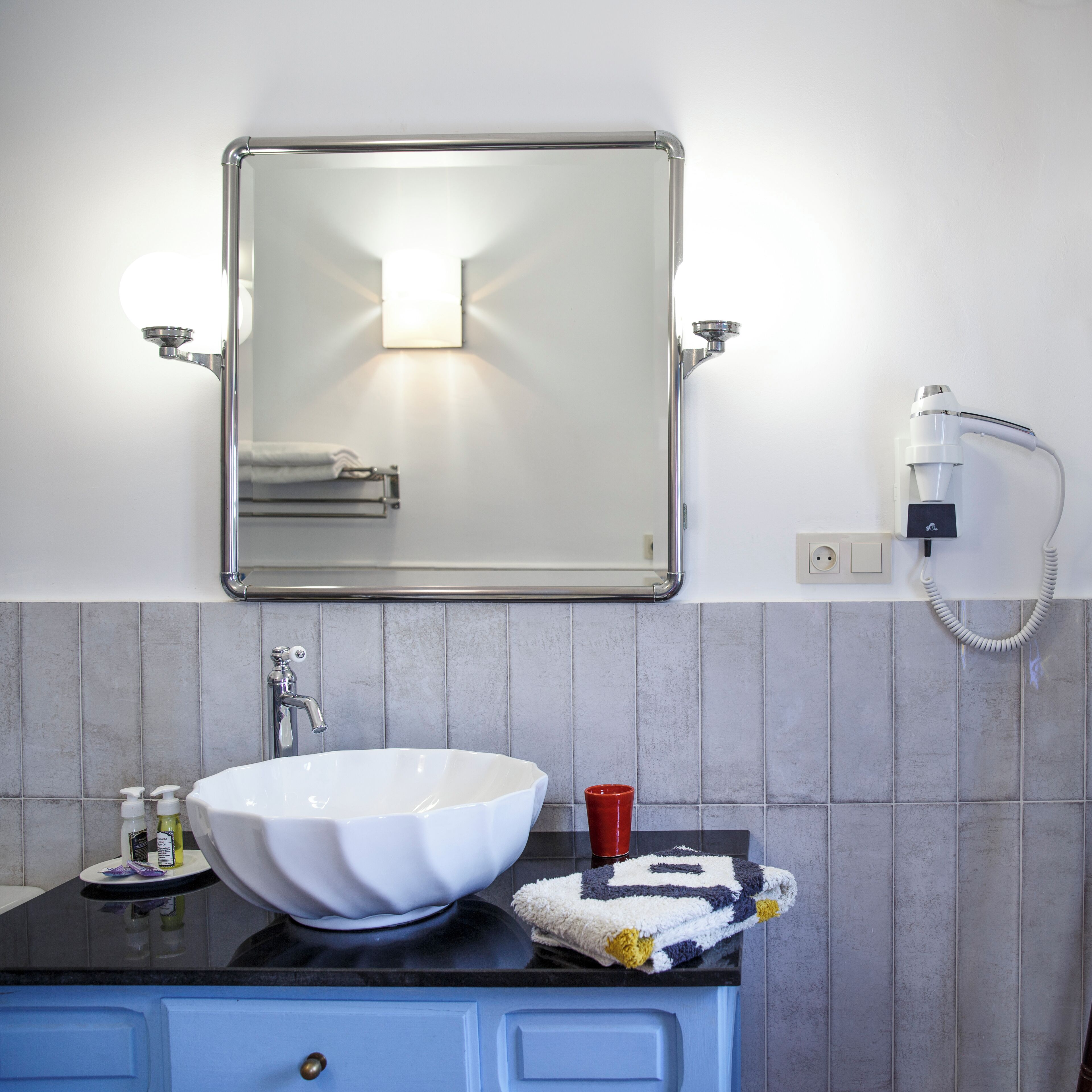 A bathroom with a white sink, a mirror, and a towel rack.