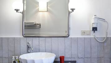 A bathroom with a white sink, a mirror, and a towel rack.