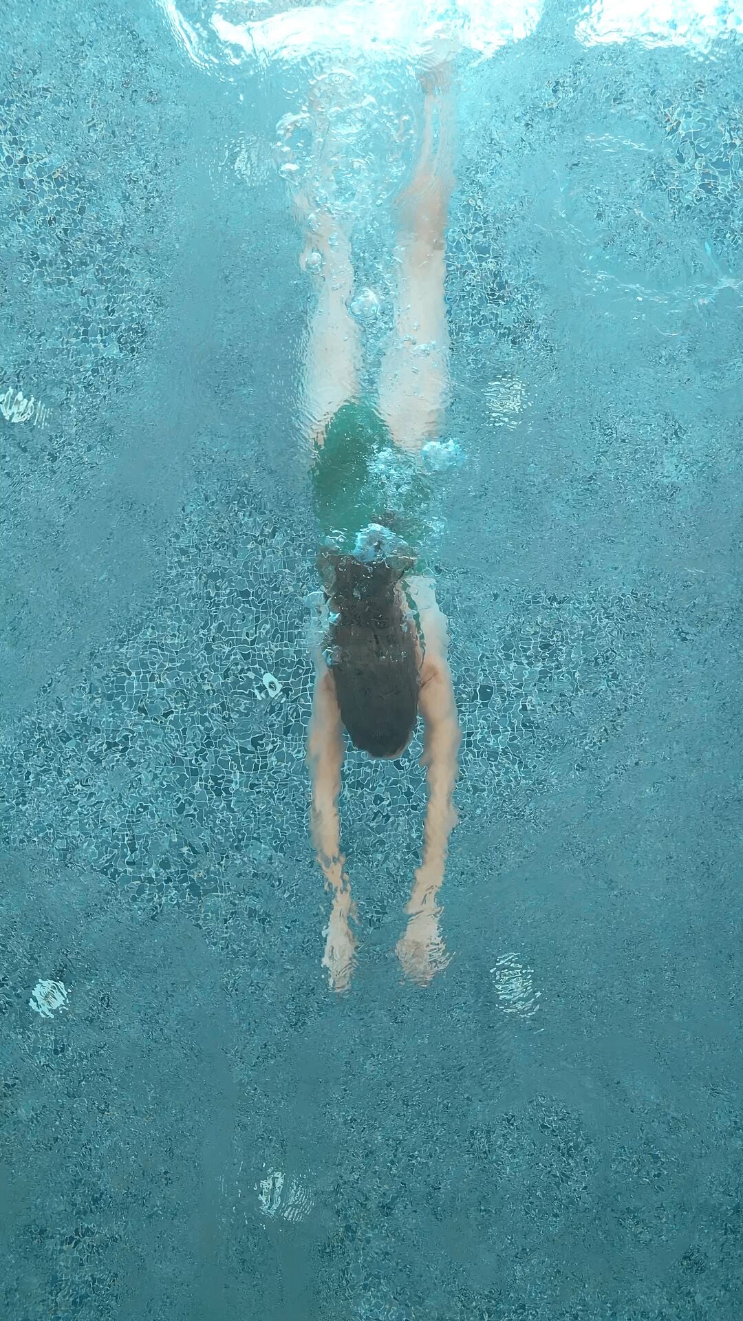 Una persona nadando en una piscina.