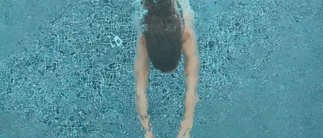 Una persona nadando en una piscina.