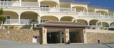 Un hotel de varios pisos con un patio central, muros de piedra y balcones.