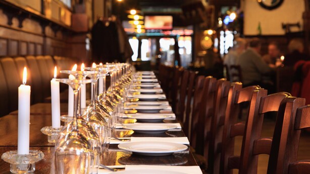 A restaurant with a long dining table set for a meal, featuring candles and glassware. - Central Inn am Hauptbahnhof (Berlin)