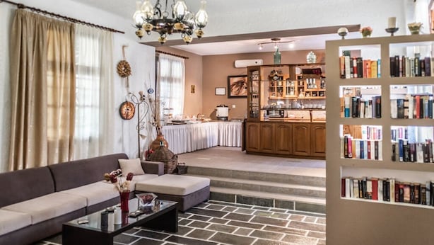 A living room with a sofa, coffee table, and a bookshelf. - Matina Hotel (Samos)