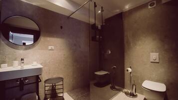 Un baño moderno con lavamanos, inodoro y ducha.
