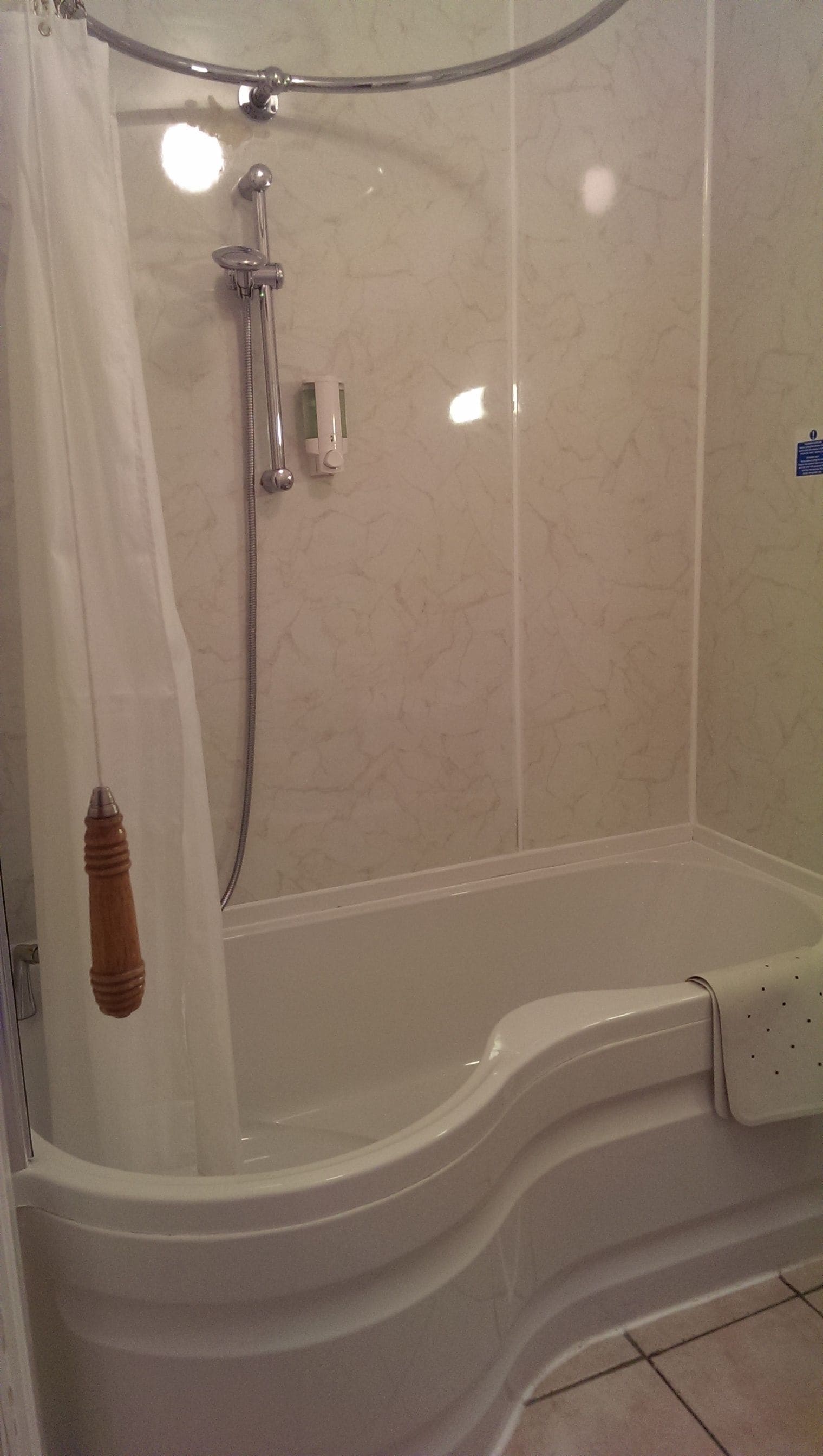 A bathroom with a bathtub, shower, and a towel rack.