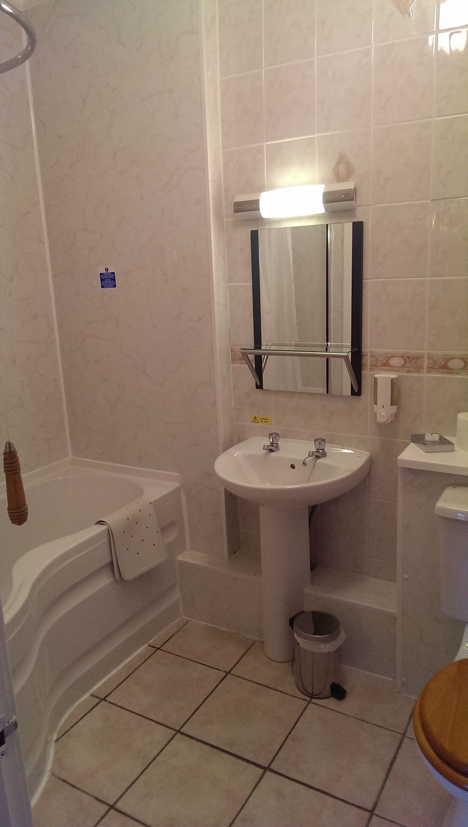 A bathroom with a bathtub, sink, toilet, and a mirror.