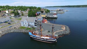 A large ship docked at a harbor with a town in the background. - The Lionstone Inn Motel and Cottages (Pictou)
