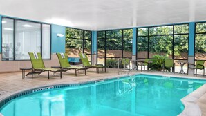 A pool area with green lounge chairs and a clear view of the outdoors. - SpringHill Suites by Marriott San Antonio SeaWorld Lackland (San Antonio)