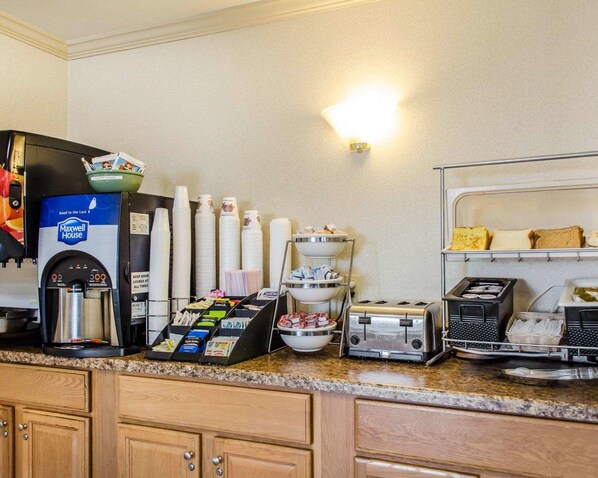 A breakfast bar with a coffee machine, toaster, and various food items.