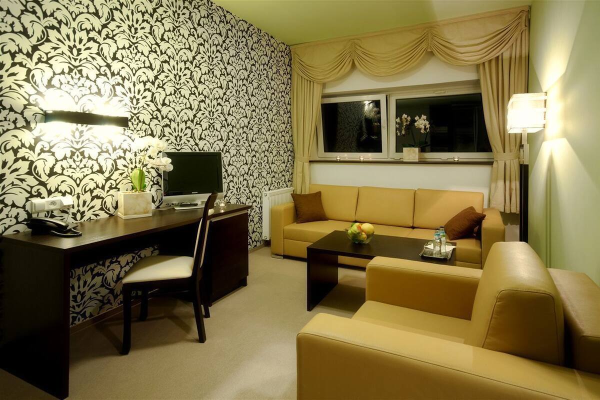 A living room with a sofa, coffee table, and a desk with a computer.