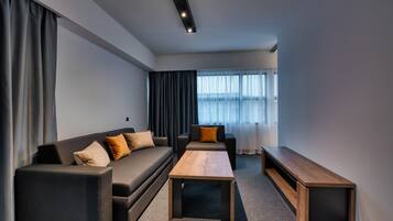 A modern living room with a sofa, two armchairs, a coffee table, and a bench.