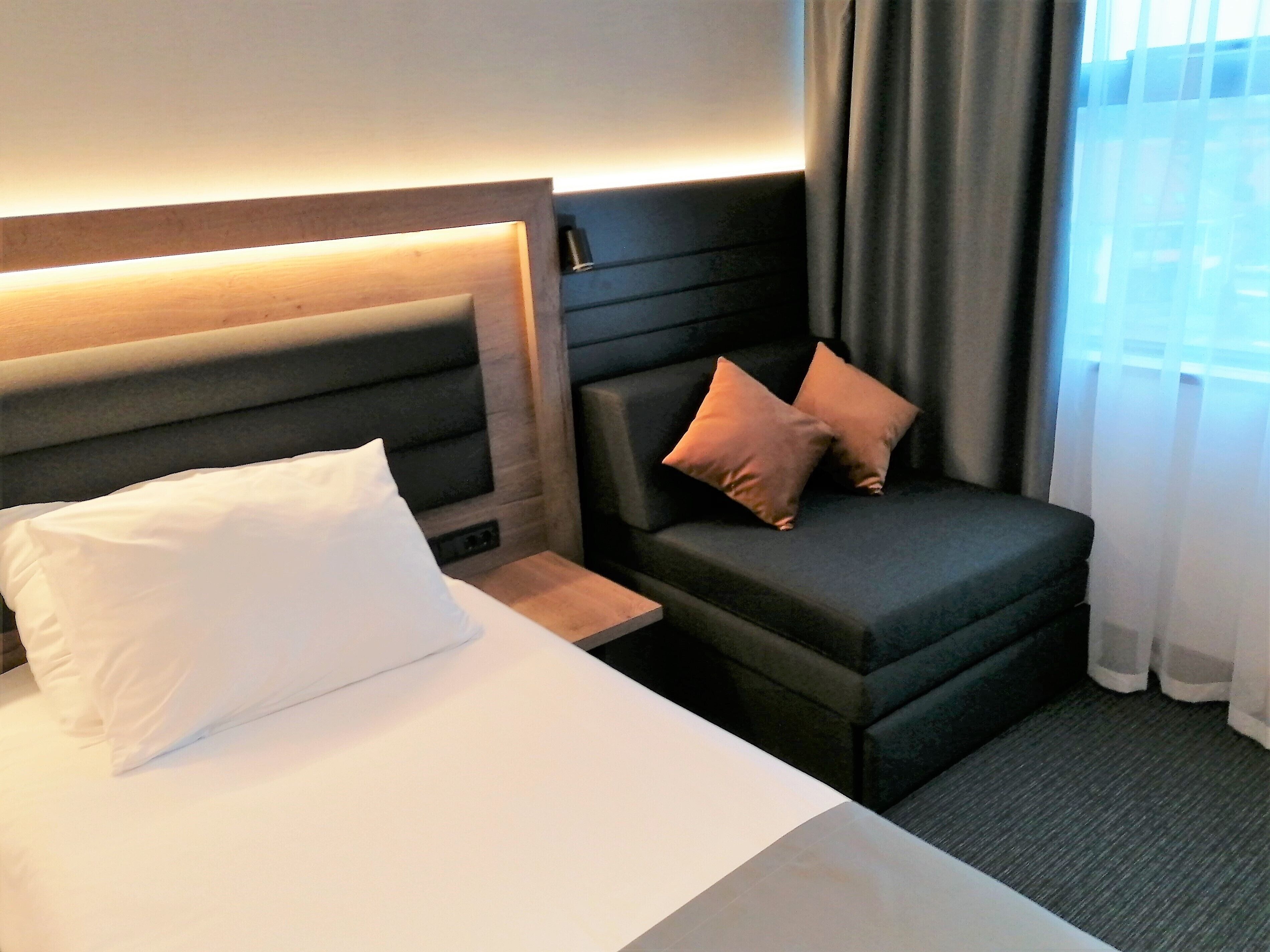 Ein Hotelzimmer mit einem Bett, einer Couch und einem Nachttisch.