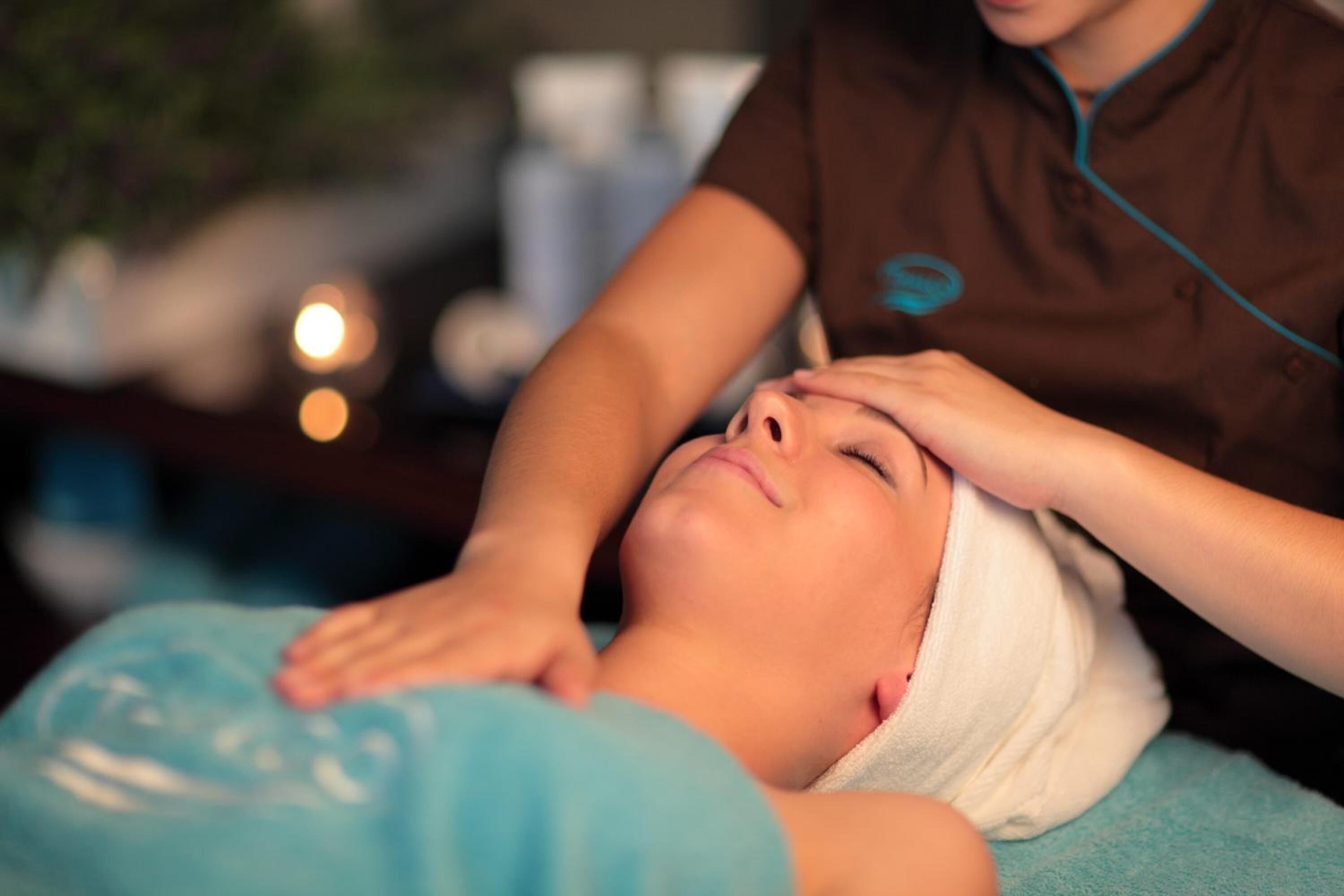 A person receiving a head massage in a spa setting.