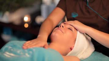A person receiving a head massage in a spa setting.