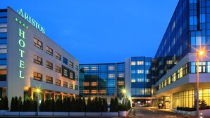 A modern hotel with a prominent sign reading "ARISTOS HOTEL" and a glass facade reflecting the evening sky. - Hotel Aristos (Zagreb)