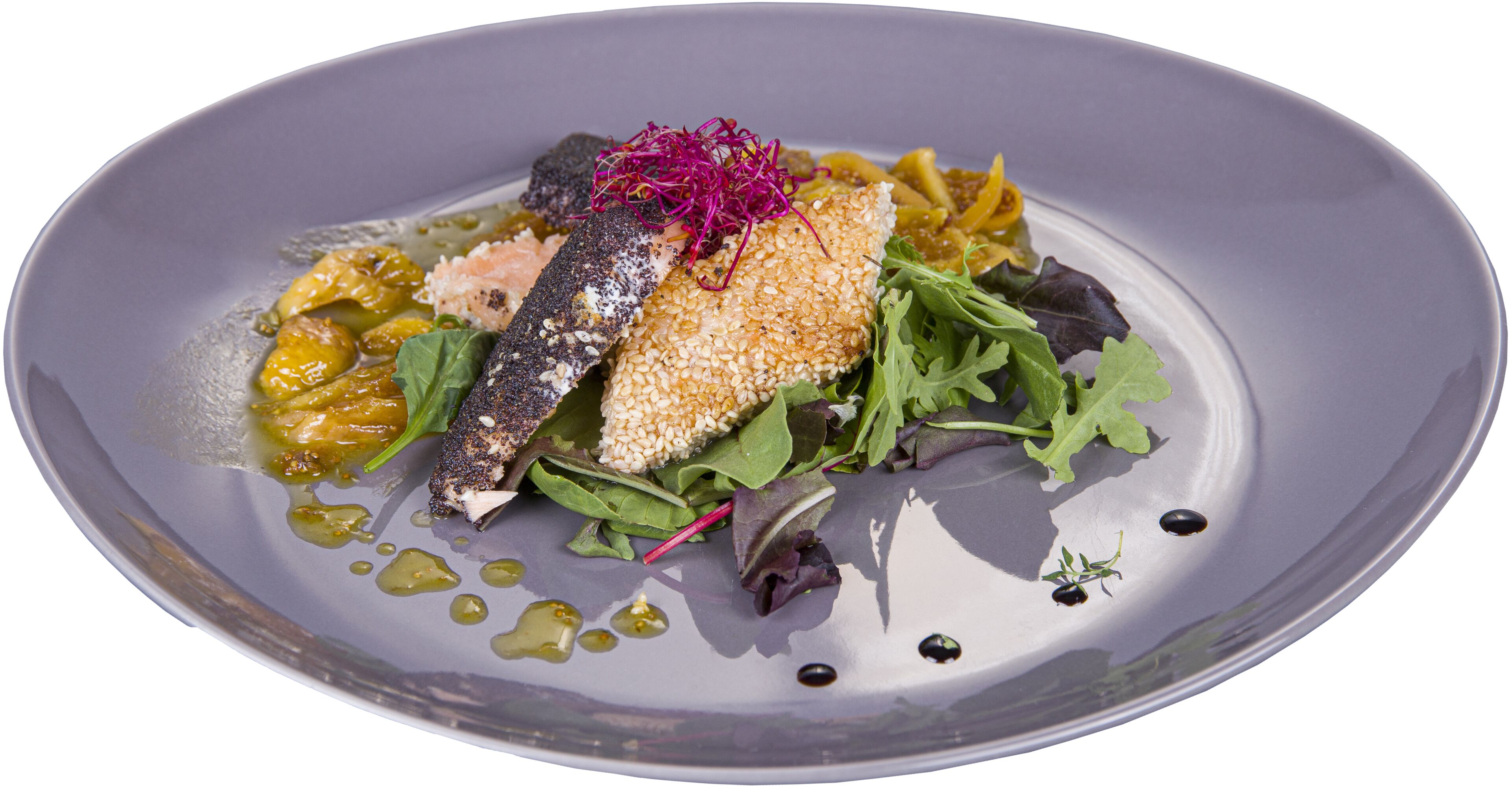 A plate of food with a fish fillet, greens, and a sauce.