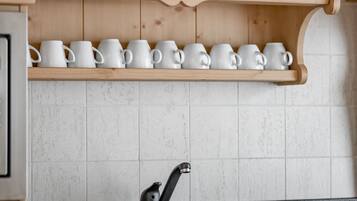Une cuisine avec des meubles de rangement en bois, un plan de travail noir et un évier.