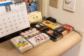 Un bureau avec un calendrier, un téléphone et divers petits objets, notamment des CD et un livre.