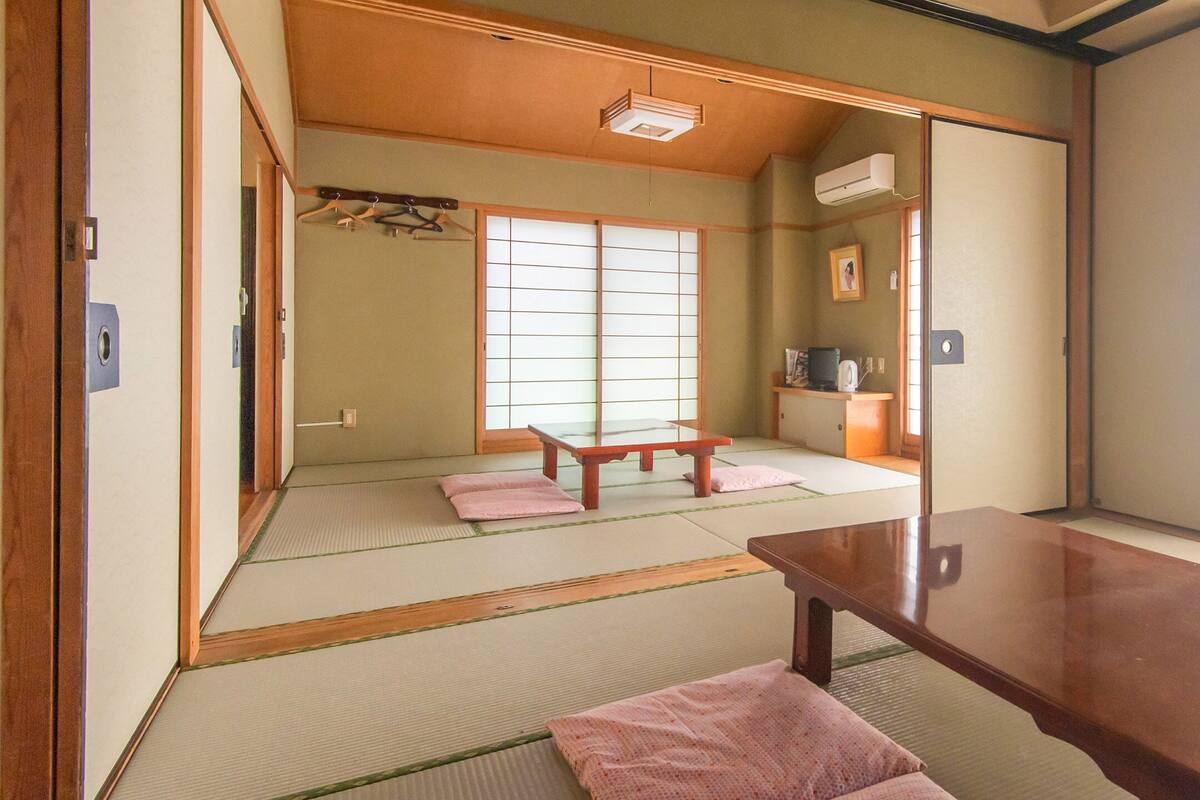 Een traditionele Japanse kamer met tatami vloeren, een lage houten tafel en een schuifdeur.