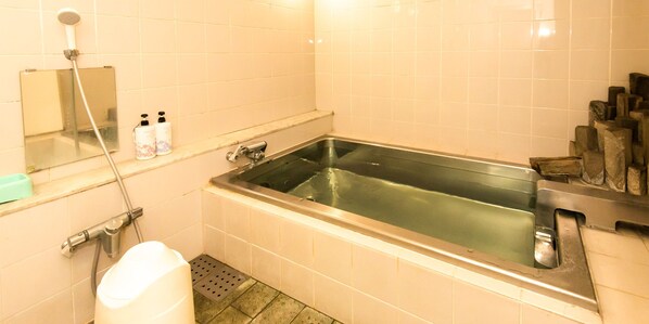 Un baño con bañera, ducha, espejo y lavamanos.