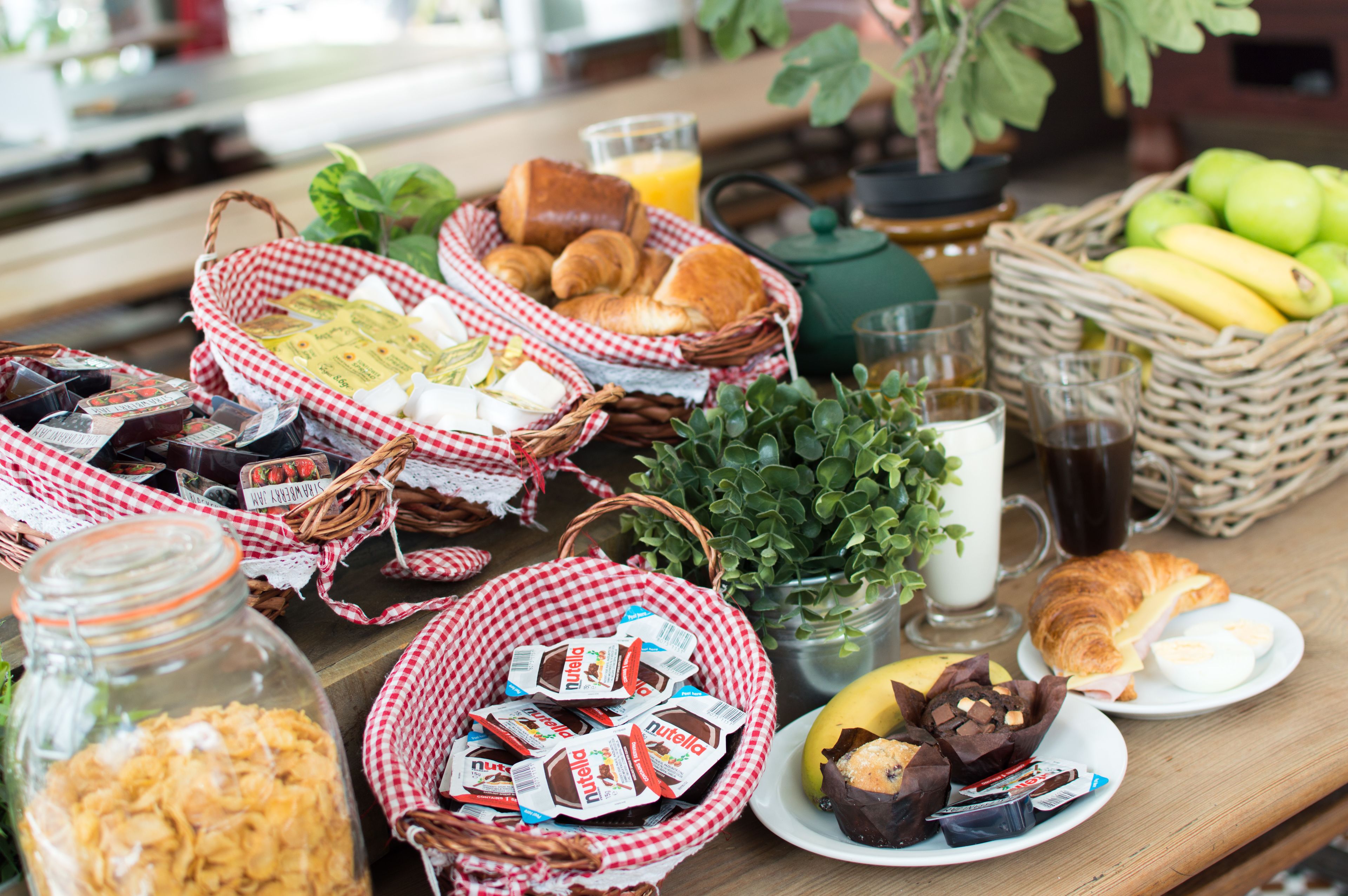 A breakfast table with various food items and drinks.