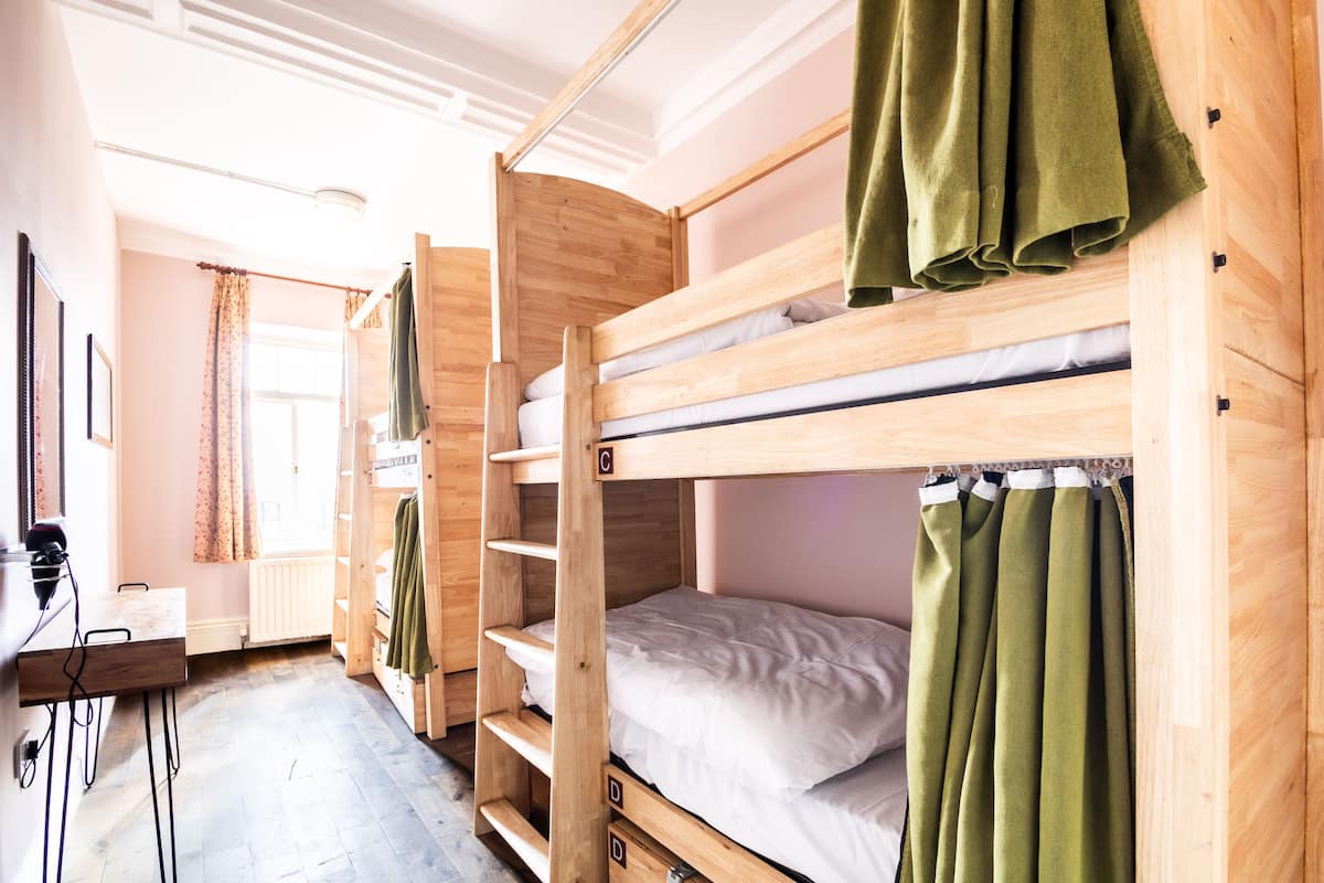 A bunk bed room with a desk and a radiator.