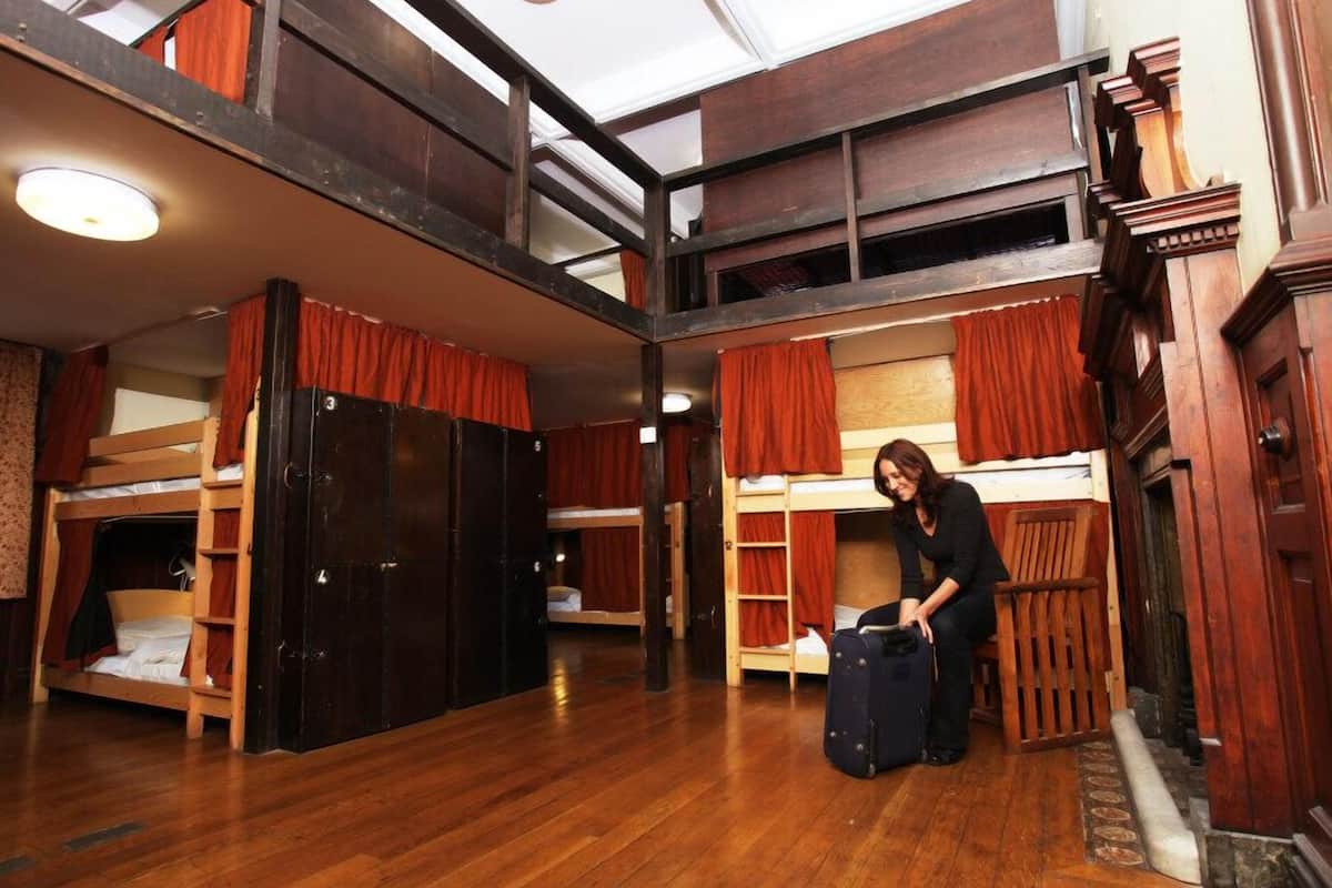 A multi-level room with bunk beds, wooden floors, and a large wardrobe.