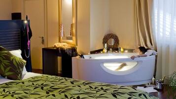 Une chambre d’hôtel avec un lit, un grand miroir, une baignoire et une fenêtre avec des rideaux.