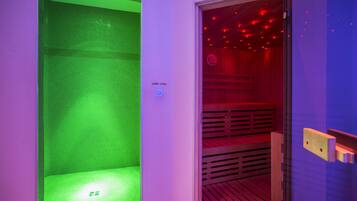 Una sala de sauna con suelo de baldosas verdes y un banco de madera.