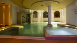 A spa area with a large pool, a sauna, and a massage room. - Hotel Norge (Trento)