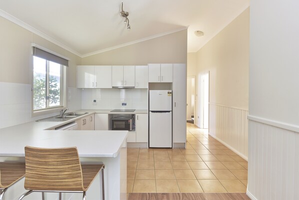 Enjoy cooking in this well-equipped kitchen with an oven, microwave, and stainless steel sink.