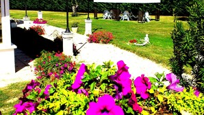 A garden with a gazebo, outdoor seating, and a pathway.