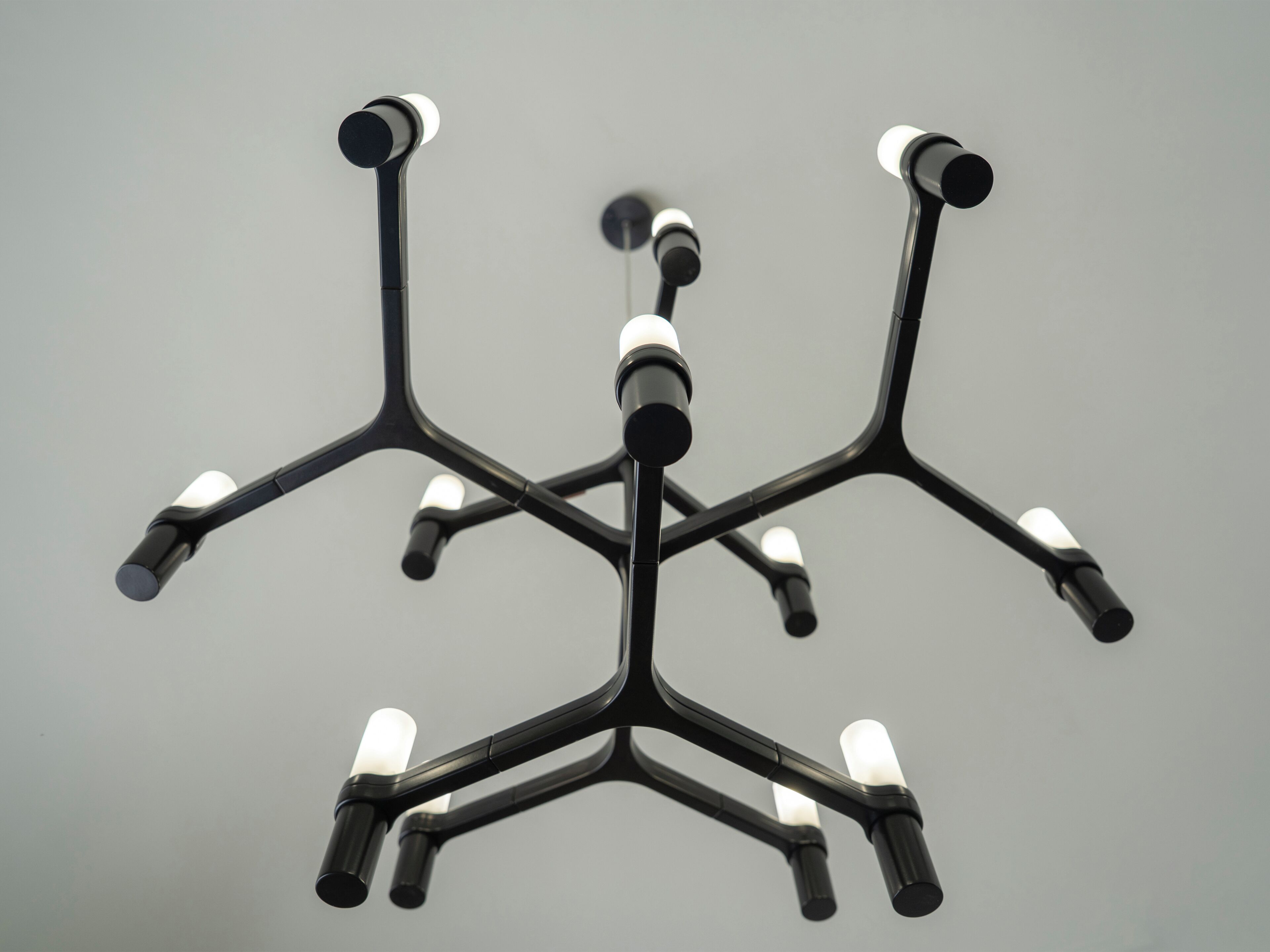 Un lustre moderne doté de plusieurs bras et de multiples points lumineux.