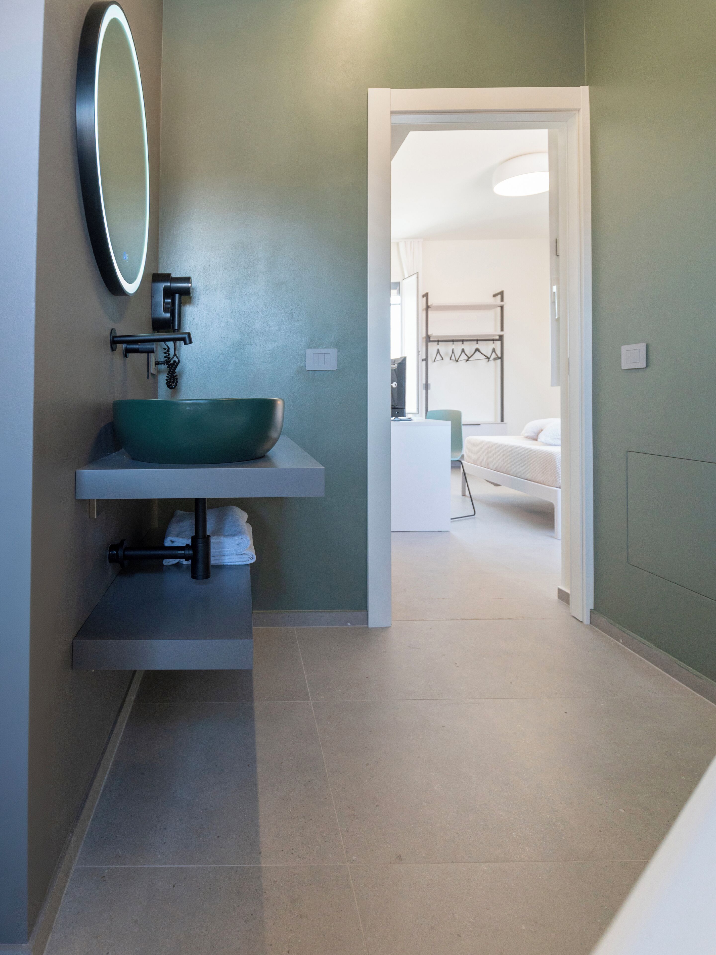 Une salle de bain avec un lavabo vert, un miroir et un porte-serviettes.