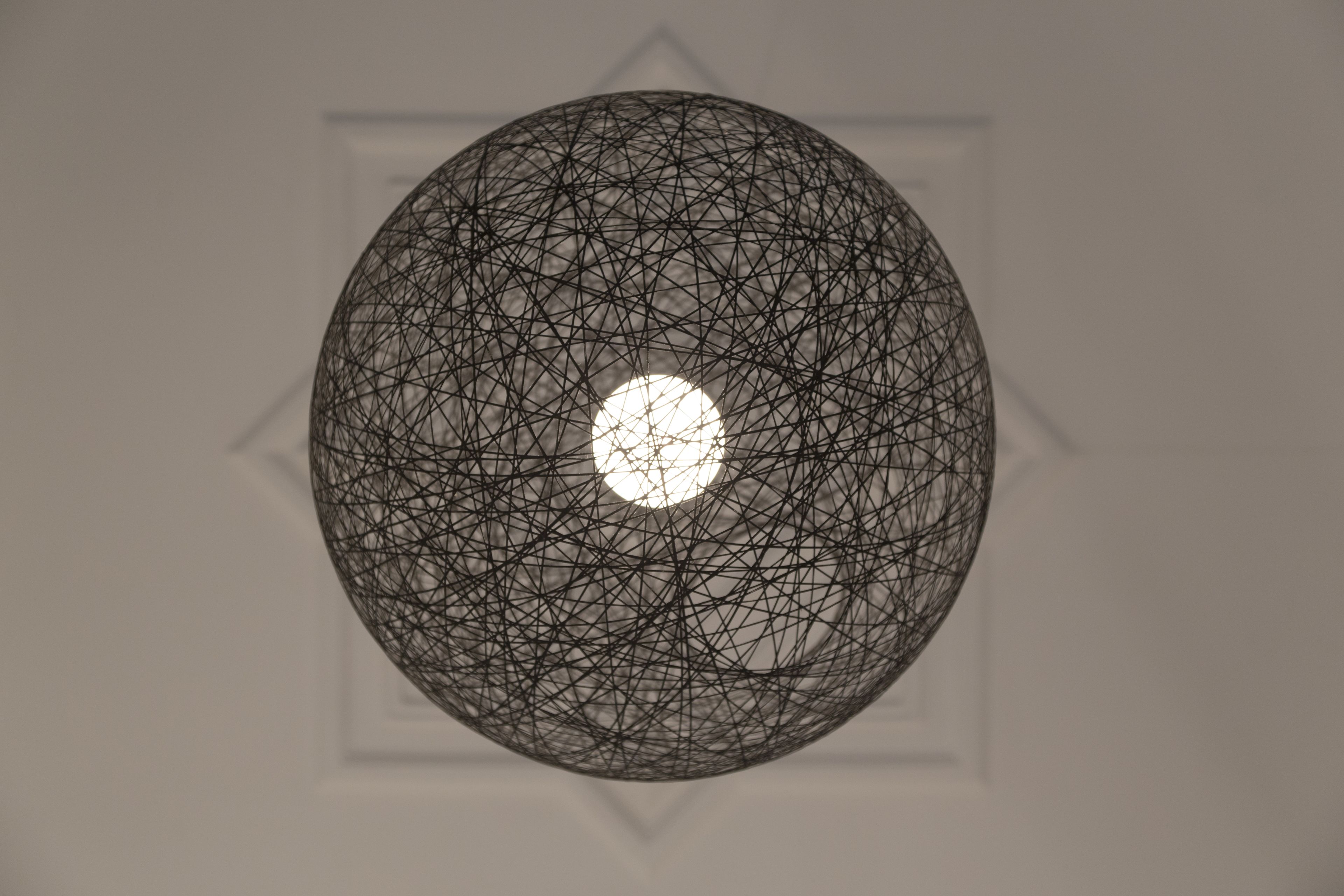 A spherical light fixture with a geometric pattern.