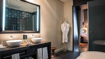 Un baño moderno con dos lavamanos grandes blancos, un espejo amplio y una bañera.